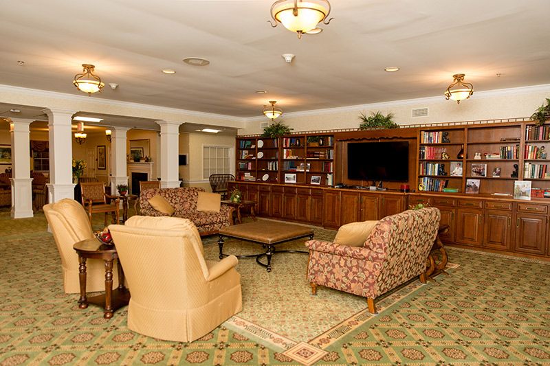 A cozy living room featuring sofas, a bookshelf, and a television.