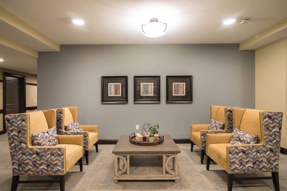 A cozy living room with stylish chairs, a central coffee table, and decorative wall art.