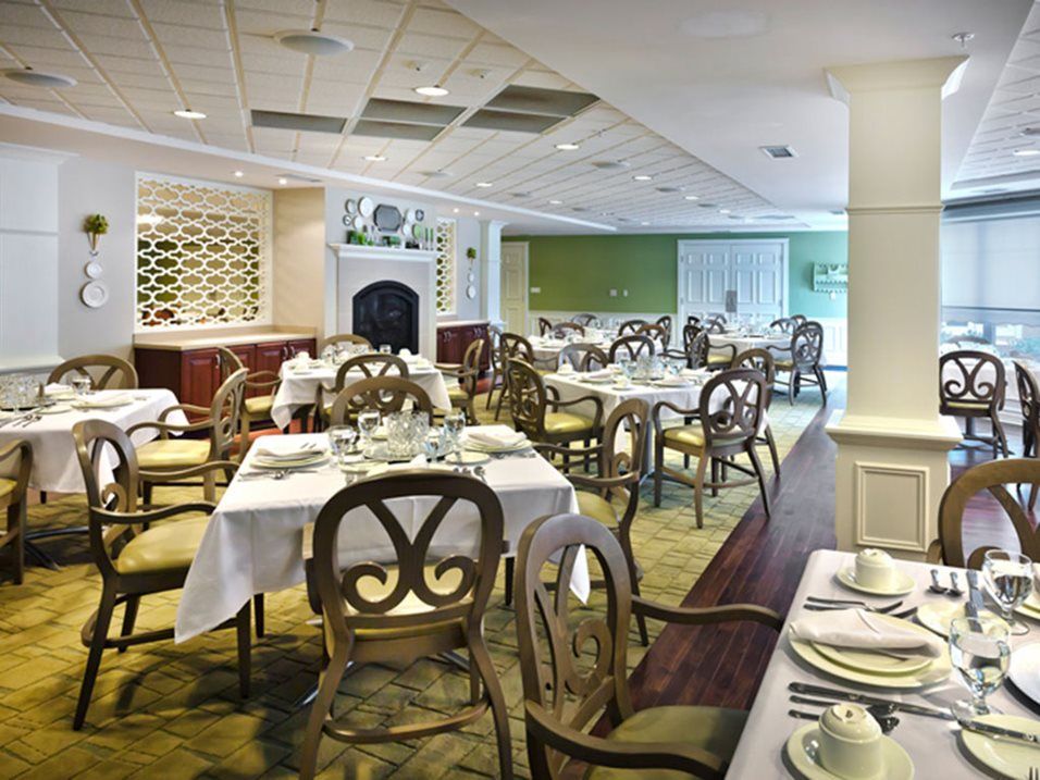 An elegant dining room with neatly set tables and chairs, ready for service.