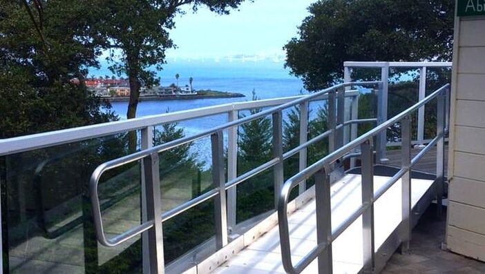 A scenic view of a waterfront with an accessible wheelchair ramp in the foreground.