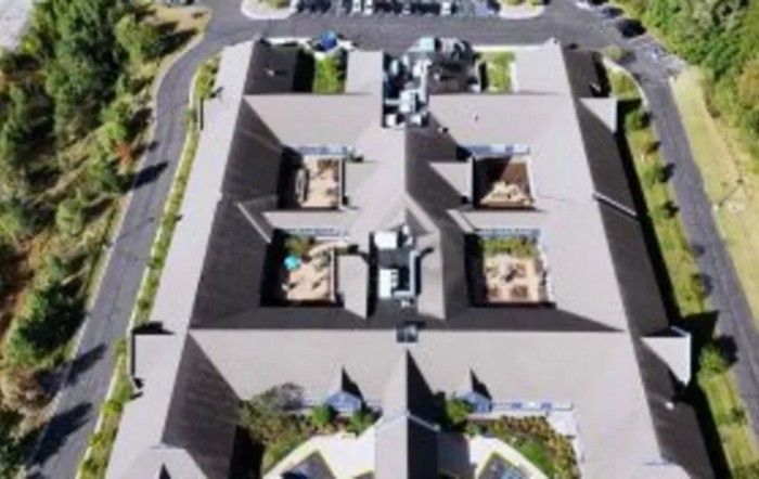 Aerial view of a series of connected buildings with distinct rooftop layouts.