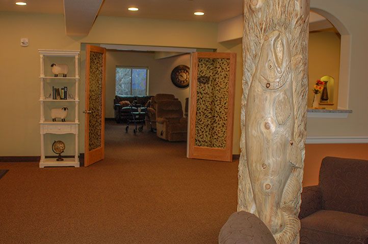 A hallway featuring carved wooden doors and a decorative pillar.