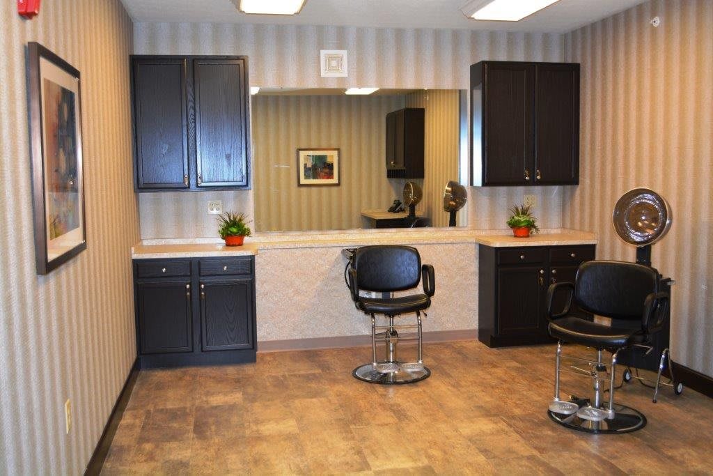 A modern hair salon interior with chairs, mirrors, and cabinets.