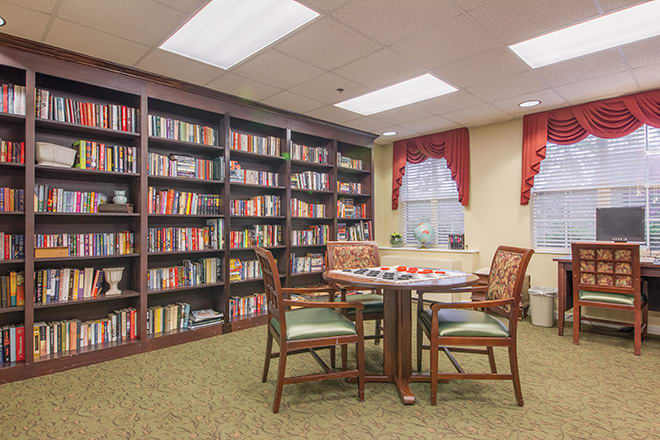 A cozy library reading area with bookshelves, a table, and chairs.