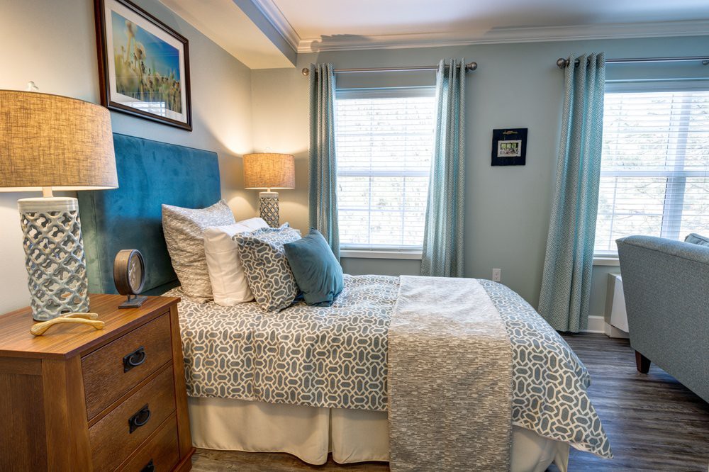 A cozy and well-decorated bedroom with a neatly made bed, decorative pillows, and soft lighting.
