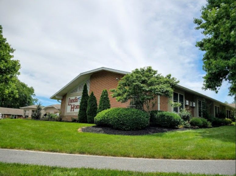 A building surrounded by well-maintained landscaping with trees and shrubs.