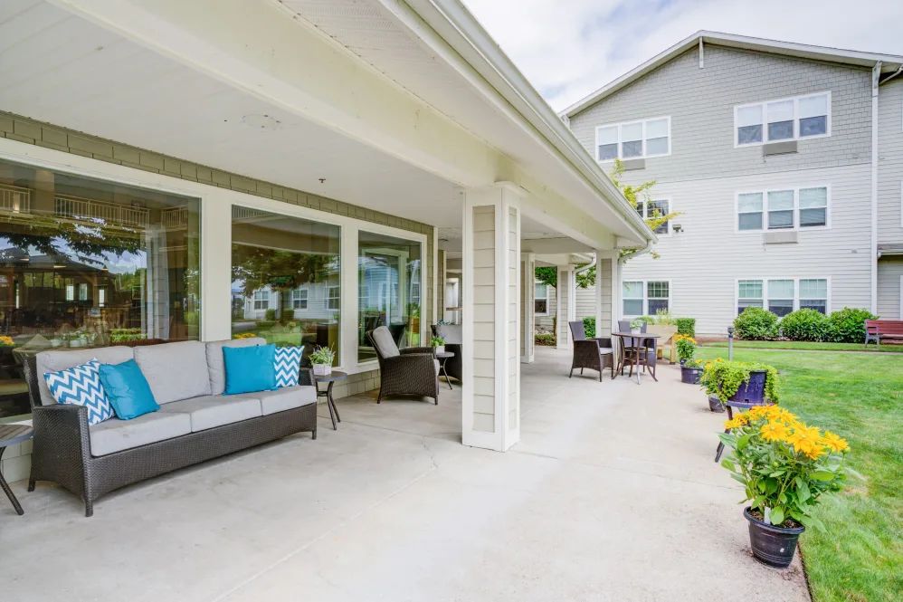 A spacious outdoor patio with comfortable seating and a view of the garden.