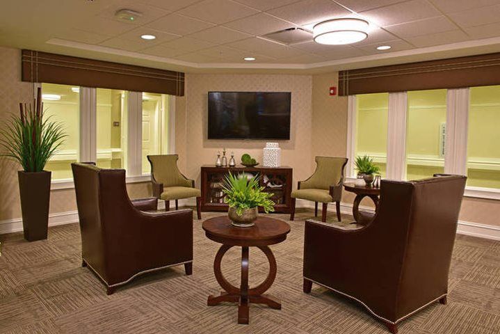 A modern living room with comfortable seating, a large TV, and indoor plants creating a cozy atmosphere.