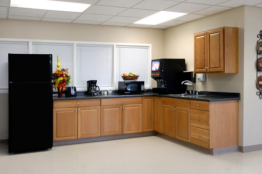 A modern kitchen featuring wooden cabinets, essential appliances, and a clean, organized layout.