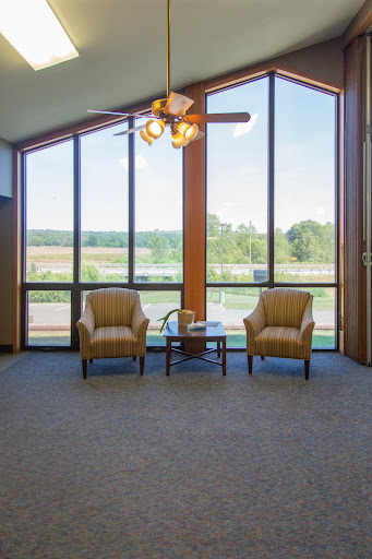 A bright and airy living space featuring two comfortable chairs and large windows offering a scenic view.