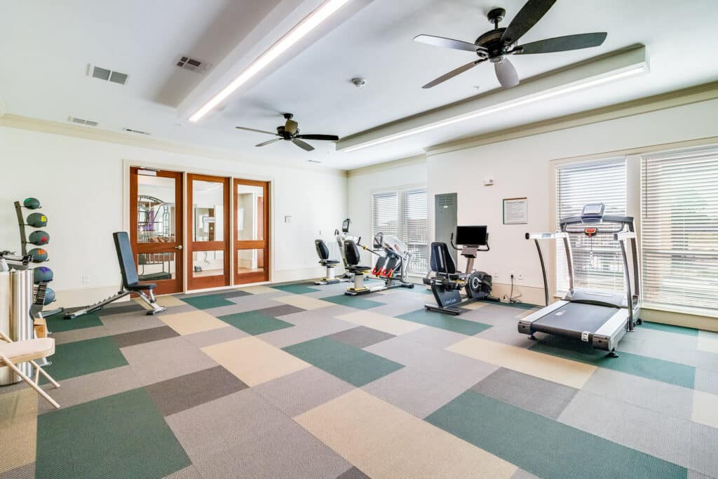 A modern gym with various exercise equipment and spacious workout area.