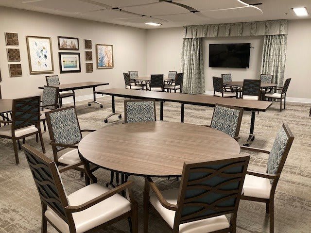 A modern conference room with tables and chairs arranged for a meeting.