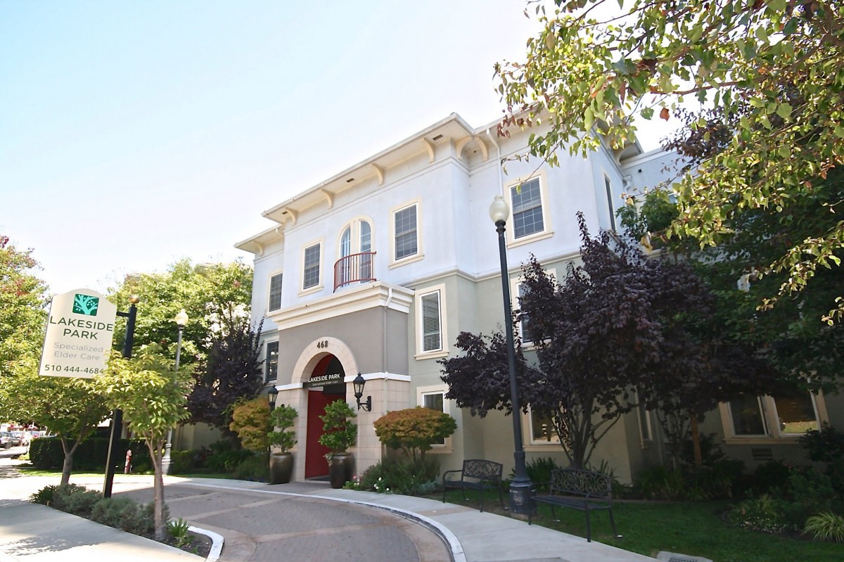 A residential building with a unique architectural design surrounded by trees and a street.