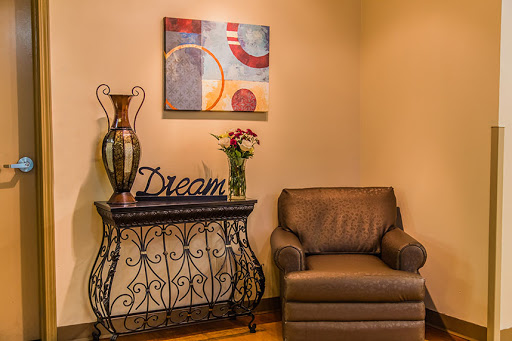 A cozy corner of a living room featuring elegant decor, a comfortable chair, and artistic elements.