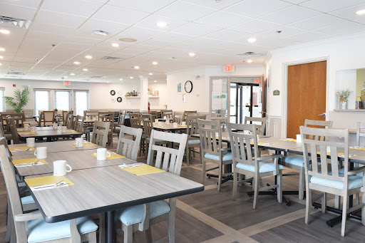 A spacious and well-lit dining area featuring modern furniture and a clean aesthetic.
