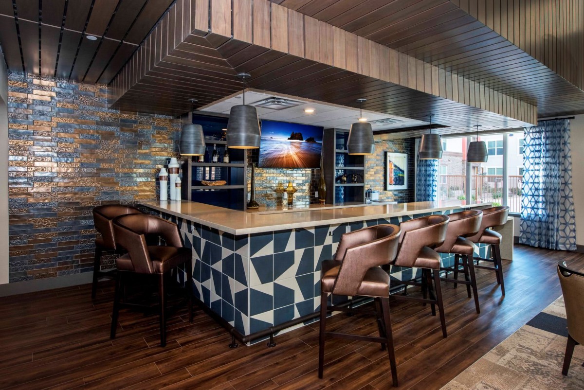 A modern bar interior with a stylish counter and comfortable seating.