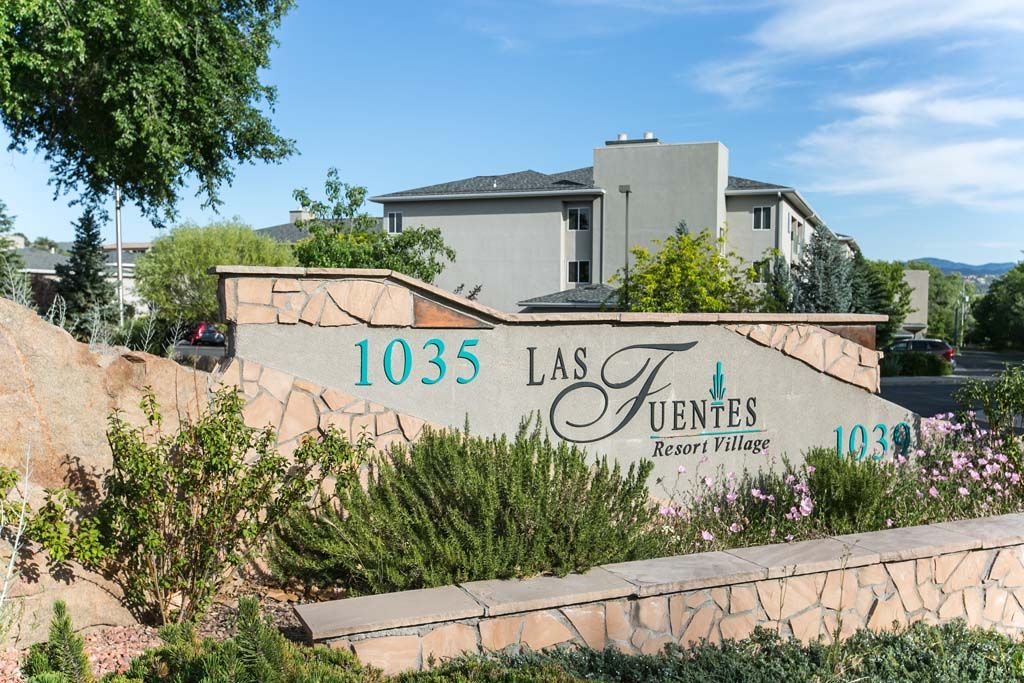 Entrance sign of Las Fuentes Resort Village with landscaped surroundings.