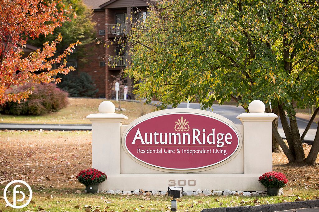 Sign for Autumn Ridge Residential Care and Independent Living surrounded by trees.