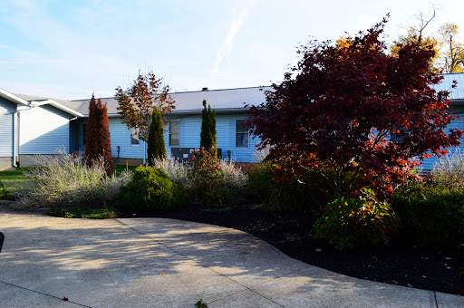 A serene view of a house with a well-maintained garden and driveway.