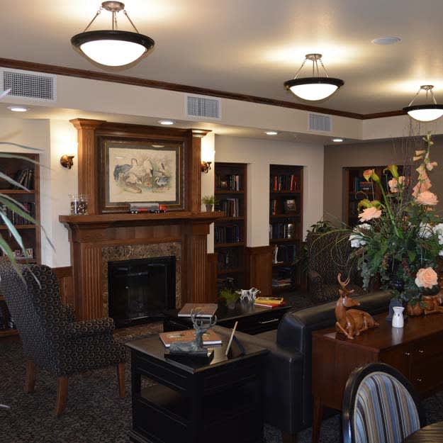 A cozy living room with a fireplace and seating area, featuring elegant decor and lighting.