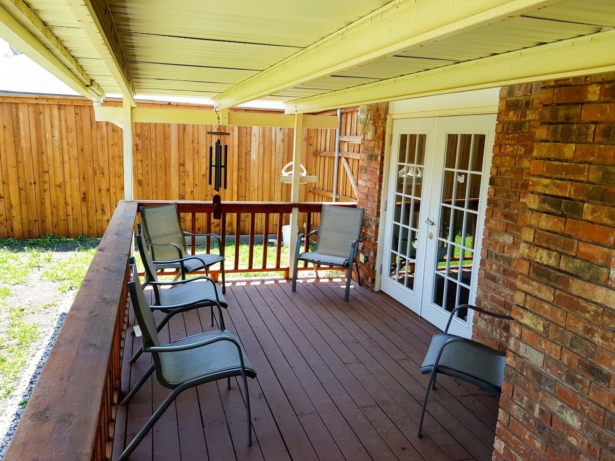 A cozy outdoor patio with seating and a wooden deck.