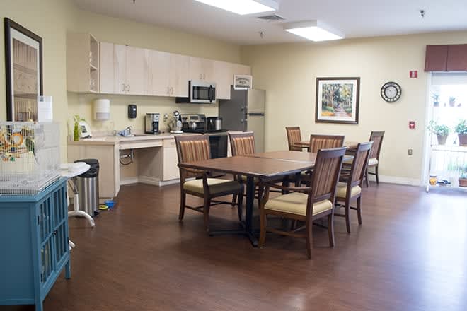 A spacious kitchen and dining area with a wooden table and chairs, equipped with modern appliances.