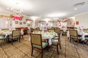 An elegant dining room with neatly arranged tables and chairs, decorated for a special occasion.