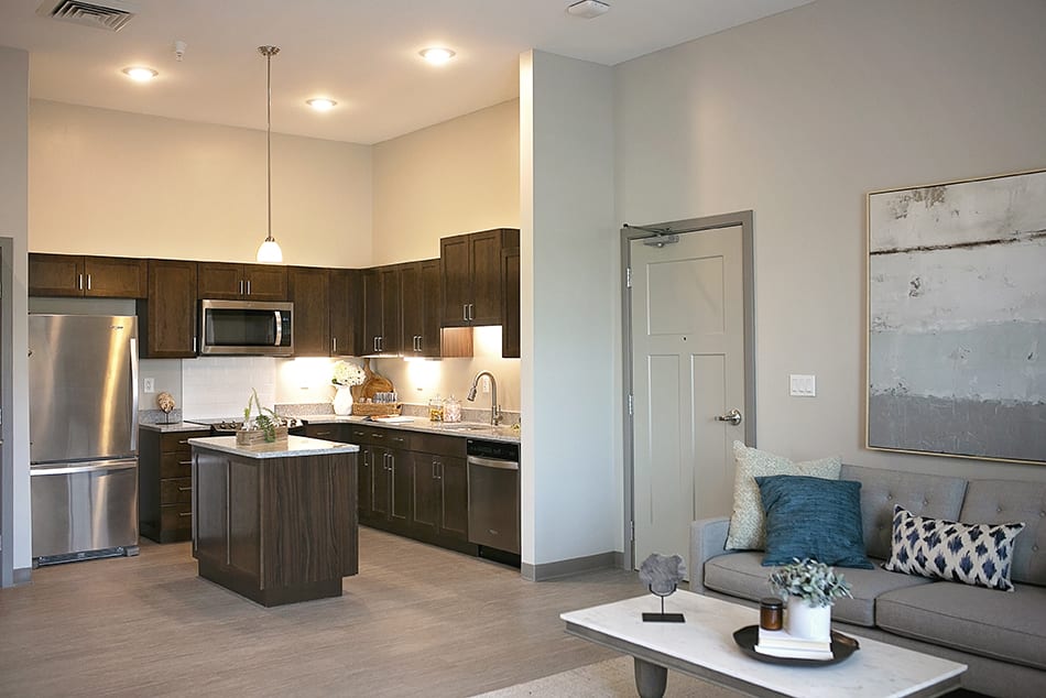 A modern kitchen and living room with open space design and stylish decor.