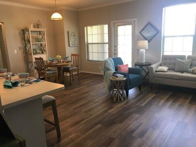 A cozy living room with wooden flooring, comfortable seating, and natural light.