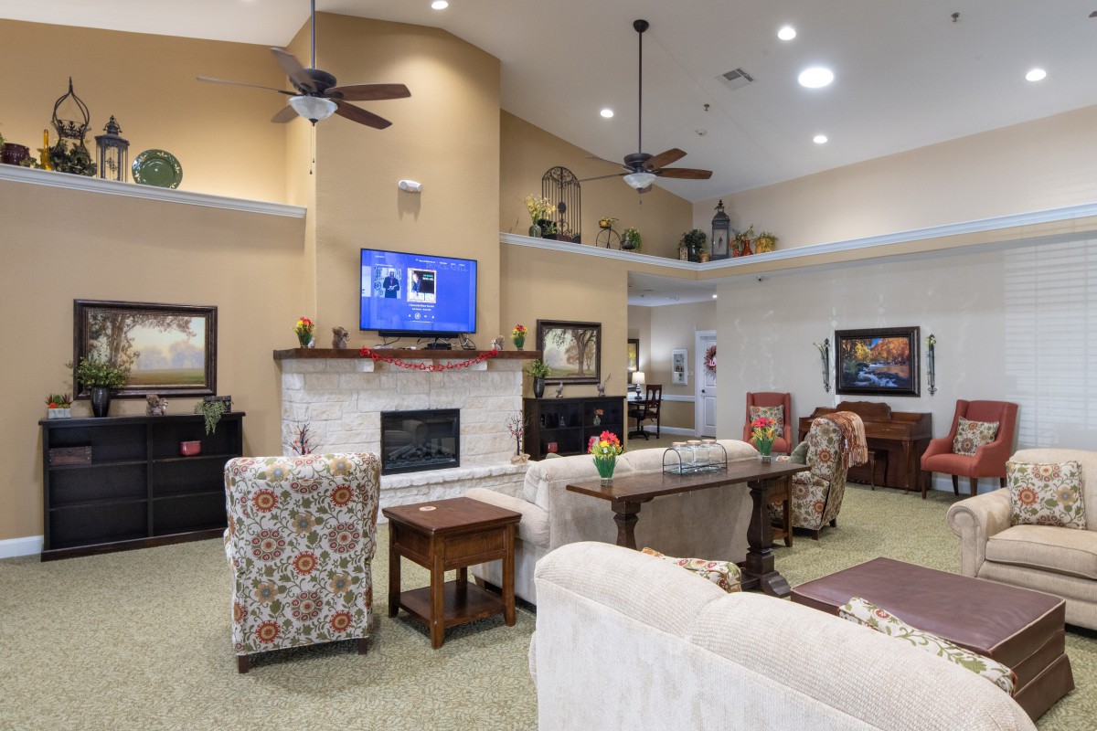 A spacious living room featuring comfortable seating, a fireplace, and a wall-mounted television.
