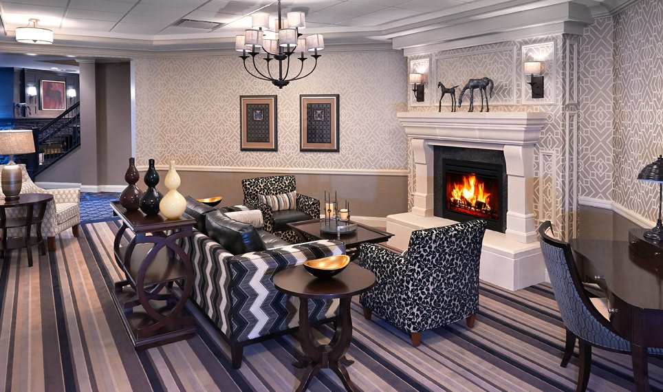 A cozy living room with a warm fireplace and stylish patterned furniture.