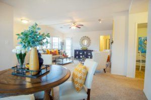 A modern and bright living room with an open dining area, featuring stylish decor and ample natural light.