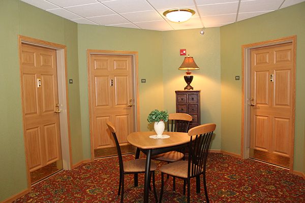 A cozy hallway corner with a wooden table and chairs, adorned with a lamp and decorative plant.