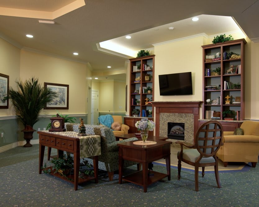 A cozy living room featuring a fireplace, bookshelves, and comfortable seating arrangements.