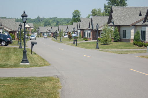A quiet suburban street lined with houses and mailboxes under a clear sky.