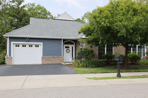 A charming residential home with blue siding and a well-maintained lawn.