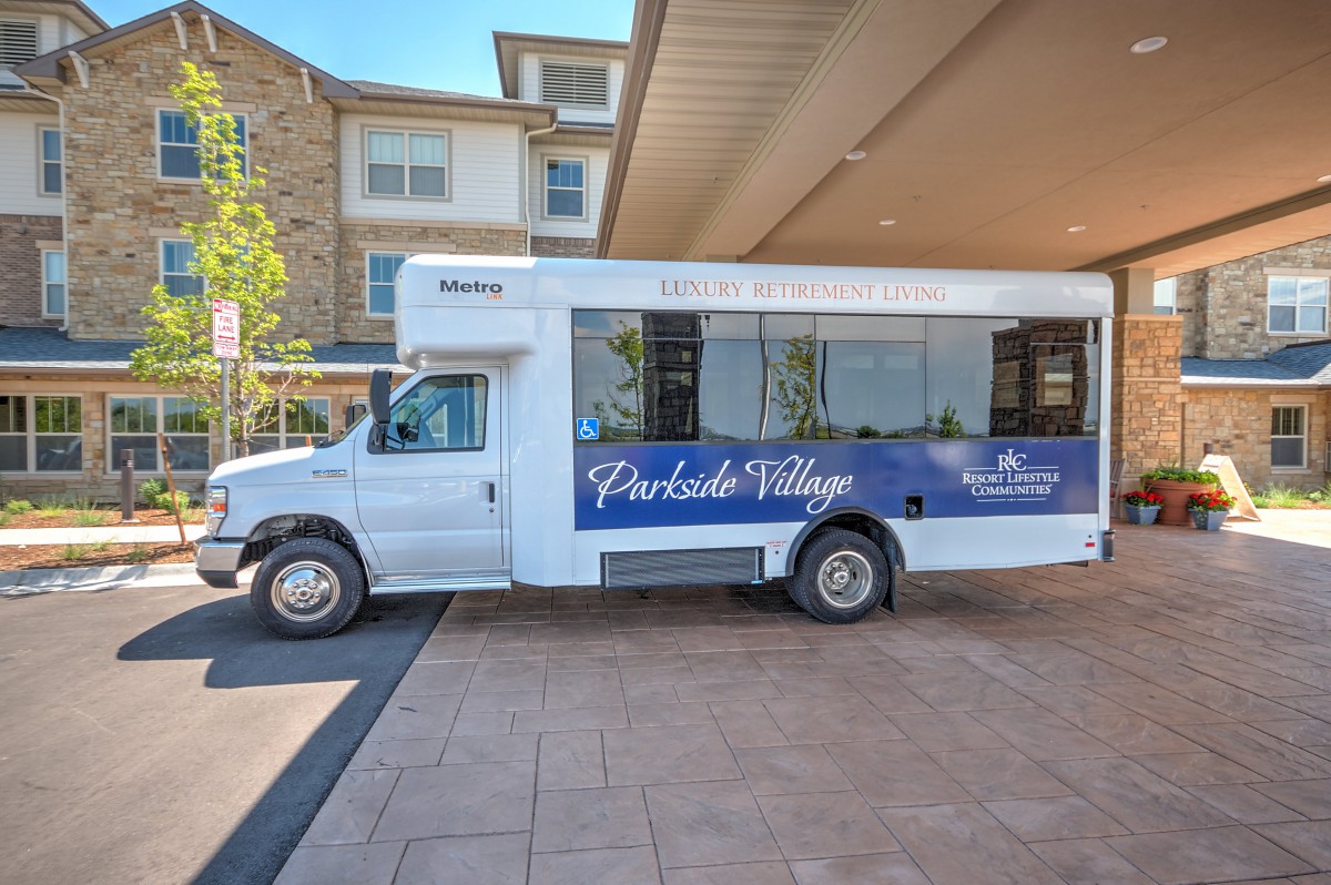 A blue and white shuttle bus parked in front of a building.