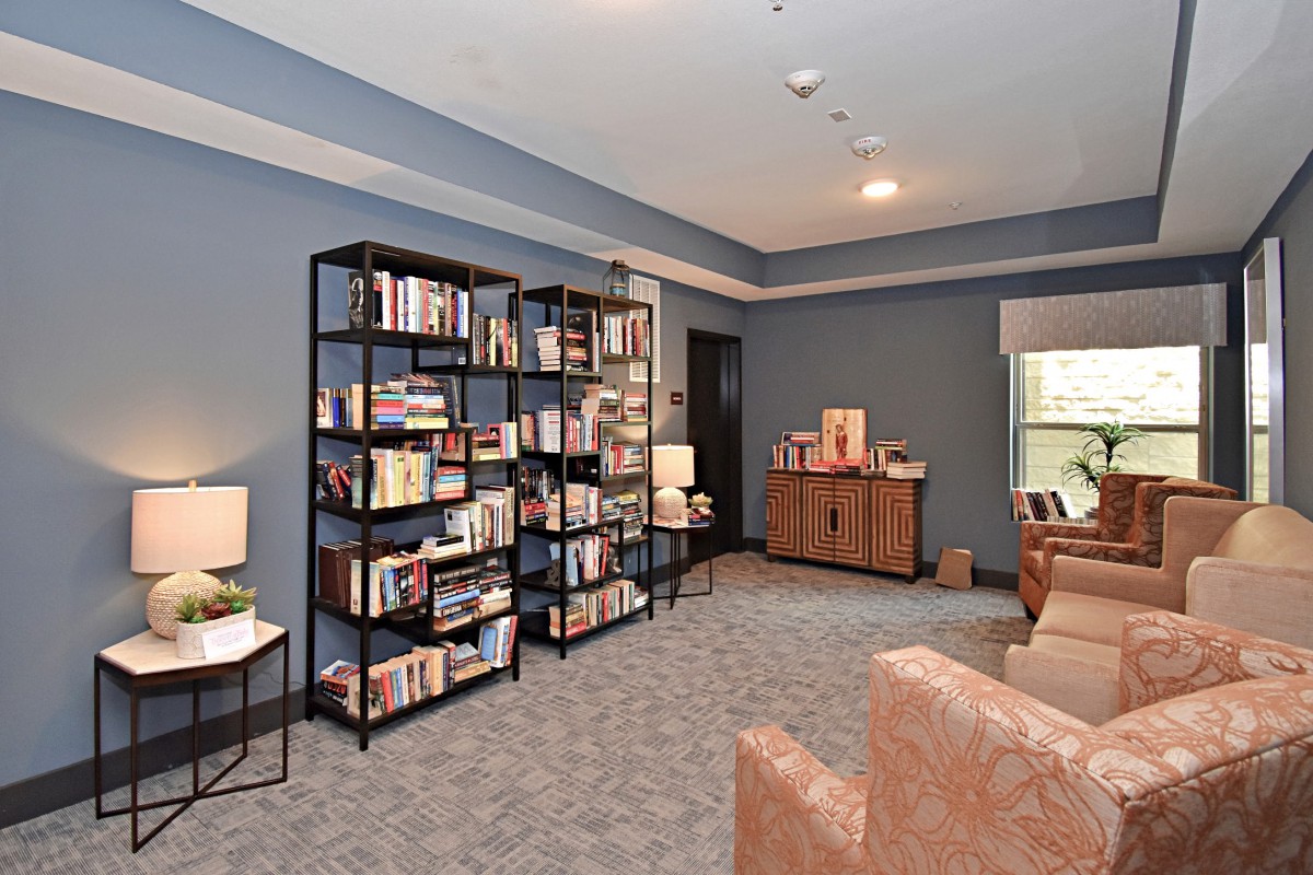 A cozy living room with bookshelves and comfortable seating.