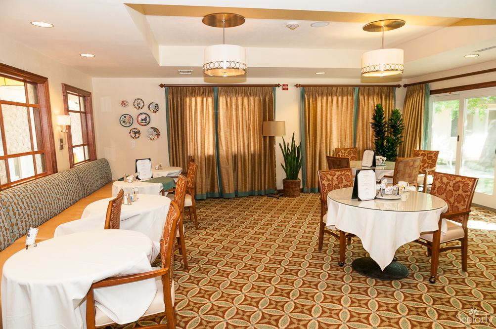 A cozy and elegantly decorated dining room with neatly arranged tables and chairs.