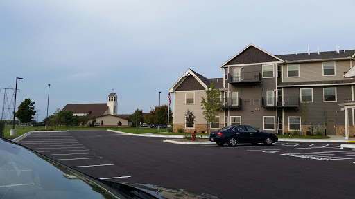 A view of a residential area featuring modern apartment buildings and a parking lot.