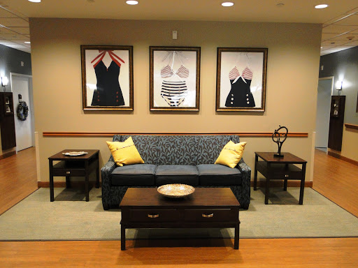 A cozy living room setup featuring a patterned sofa, two small side tables, and framed artwork on the wall.