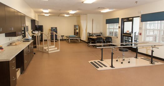 A spacious rehabilitation center equipped with various physical therapy apparatuses.