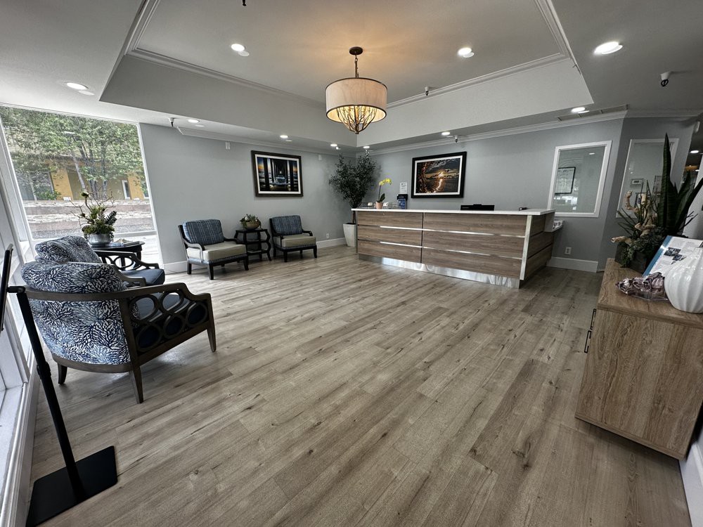 Modern reception area with seating and a wooden desk.