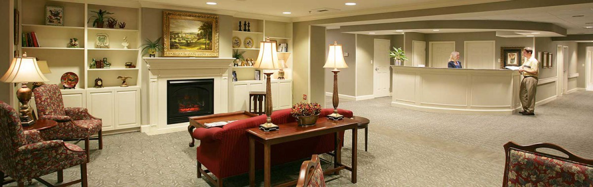 A cozy living room with elegant interior design, featuring a red sofa, lamps, and a fireplace.