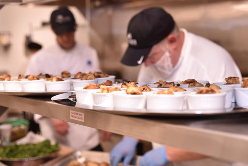 Chefs preparing and plating dishes in a busy kitchen.