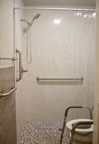 An accessible shower with grab bars and a shower chair.