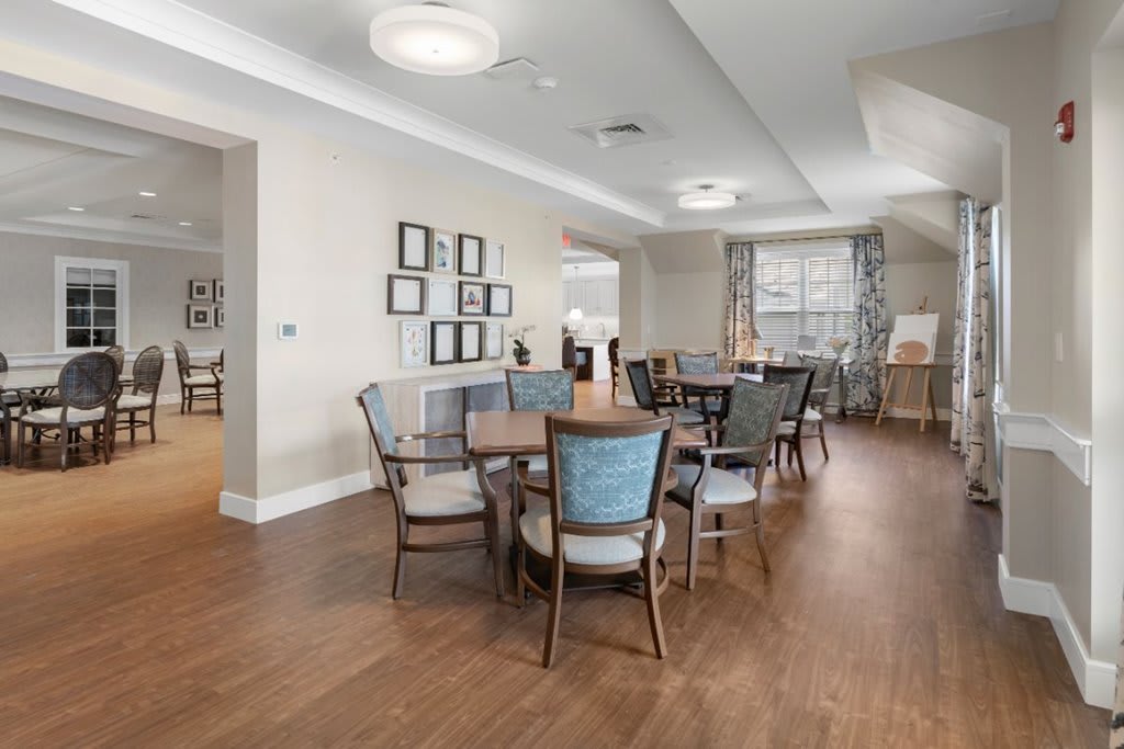 A modern dining area with elegant wooden flooring, stylish chairs, and ample natural lighting.