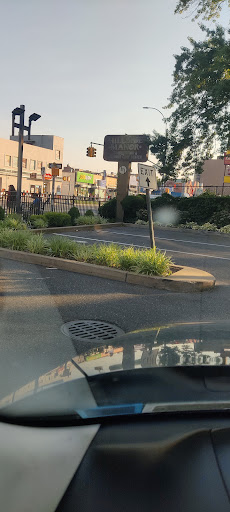 A view of a parking area with greenery and signage in an urban setting.
