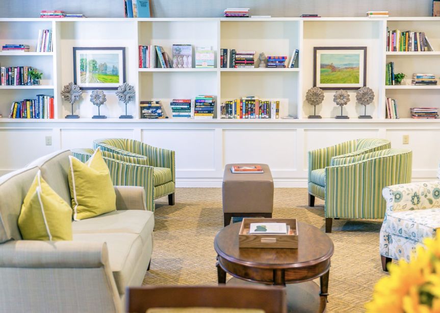 A modern library room with comfortable seating and bookshelves.