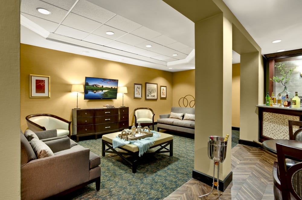 A cozy lobby seating area with comfortable furniture and a wall-mounted television.